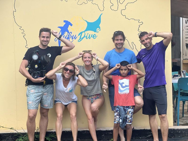 Group of smiling divers in front of the Nuku-Dive centre